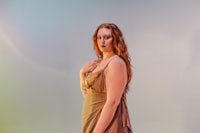 a woman in a long dress posing with her hands on her hips