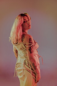 a woman in a dress with tattoos posing