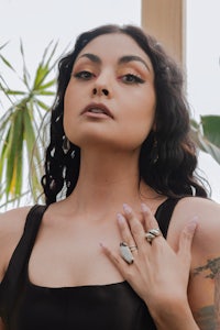 a woman with tattoos posing in front of a plant