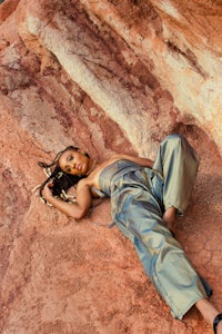 a woman laying on top of a rock
