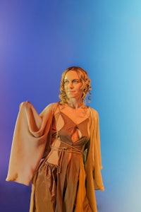 a woman in a brown dress standing on a blue background