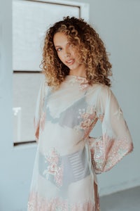 a beautiful woman in a floral robe posing in a room