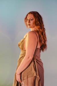 a woman in a brown dress posing for a photo